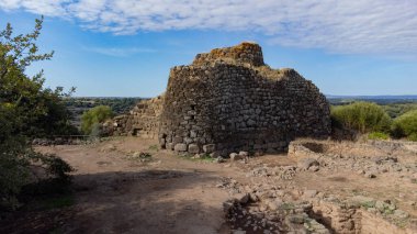View of the Nuraghe Iloi archaeological site in Sedilo, Sardinia, featuring ancient basalt stone walls and panoramic landscape