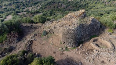 View of the Nuraghe Iloi archaeological site in Sedilo, Sardinia, featuring ancient basalt stone walls and panoramic landscape