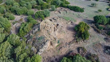 View of the Nuraghe Iloi archaeological site in Sedilo, Sardinia, featuring ancient basalt stone walls and panoramic landscape