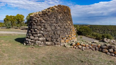 View of the Nuraghe Sa Jua archaeological site in Aidomaggiore, Sardinia, with basalt stones and surrounding countryside