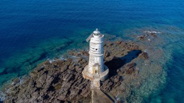 Turkuaz deniz ve kayalık kıyılarla çevrili tarihi Mangiabarche Deniz Feneri 'nin havadan görünüşü
