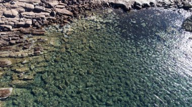 Şeffaf turkuaz suyun hava manzarası Sardunya kıyı şeridi boyunca kayalık oluşumları ortaya çıkarıyor..