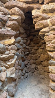 İtalya 'nın Sardunya kentindeki bir Nuraghe taş yapısının arkeolojik kalıntıları, yabani bitki örtüsüyle çevrili.