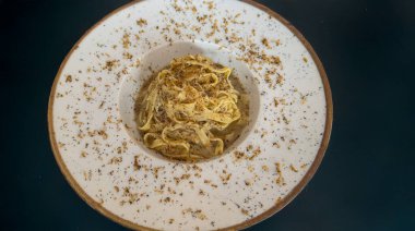 Zarif bir tabakta servis edilen trüf mantarlı gurme tagliatelle makarnası.