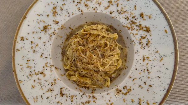 Zarif bir tabakta servis edilen trüf mantarlı gurme tagliatelle makarnası.