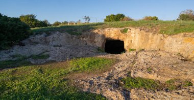 Antik kaya kesimi Domus de Janas mezar girişi sıcak günbatımı ışığıyla aydınlatıldı
