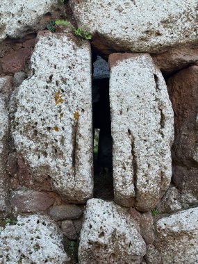 Nuraghe Arrubiu antik megalitik duvar ve parlak güneş ışığında giriş