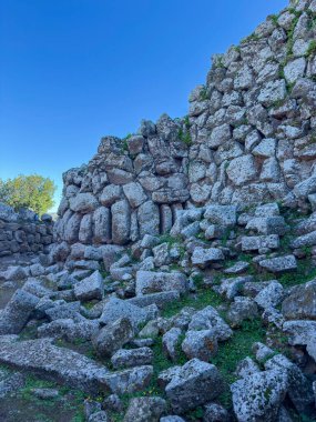 Nuraghe Arrubiu antik megalitik duvar ve parlak güneş ışığında giriş