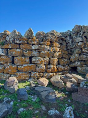 Nuraghe Arrubiu antik megalitik duvar ve parlak güneş ışığında giriş