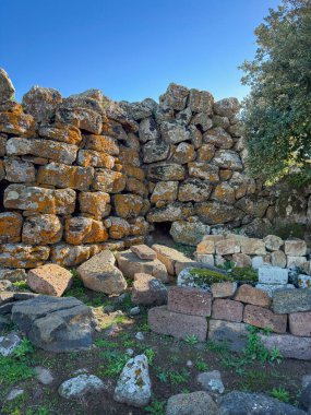 Nuraghe Arrubiu antik megalitik duvar ve parlak güneş ışığında giriş