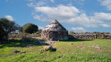 Nuraghe Arrubiu antik megalitik duvar ve parlak güneş ışığında giriş