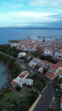 SantAntioco adasındaki Calasetta kulesinin, beyaz binaların ve limanın havadan görüntüsü..