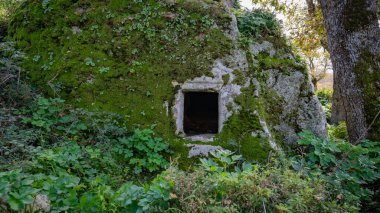 Sardunya 'nın dramatik gökyüzü altında yeşil manzaradan yükselen tarih öncesi nuraghe taşı yapısı
