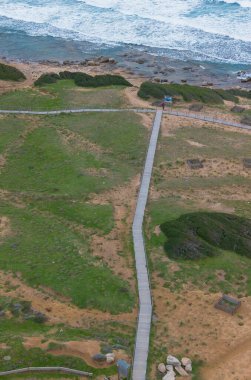 Uçan okyanus dalgalarının engebeli kayalıklara ve vahşi kıyı şeridine çarpması..