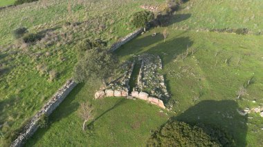 Sardunya 'nın yeşil kırsal kesimleriyle çevrili antik bir Dev Mezar arkeolojik sahasının havadan görünüşü.