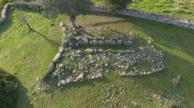 Sardunya 'nın yeşil kırsal kesimleriyle çevrili antik bir Dev Mezar arkeolojik sahasının havadan görünüşü.