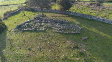 Sardunya 'nın yeşil kırsal kesimleriyle çevrili antik bir Dev Mezar arkeolojik sahasının havadan görünüşü.
