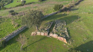 Sardunya 'nın yeşil kırsal kesimleriyle çevrili antik bir Dev Mezar arkeolojik sahasının havadan görünüşü.