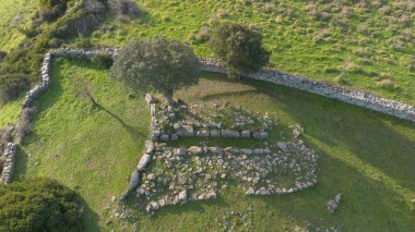 Sardunya 'nın yeşil kırsal kesimleriyle çevrili antik bir Dev Mezar arkeolojik sahasının havadan görünüşü.