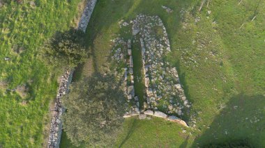 Sardunya 'nın yeşil kırsal kesimleriyle çevrili antik bir Dev Mezar arkeolojik sahasının havadan görünüşü.