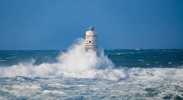 Güçlü fırtına dalgaları, ıssız bir deniz fenerine çarpıyor. Açık deniz koşullarında duruyor..