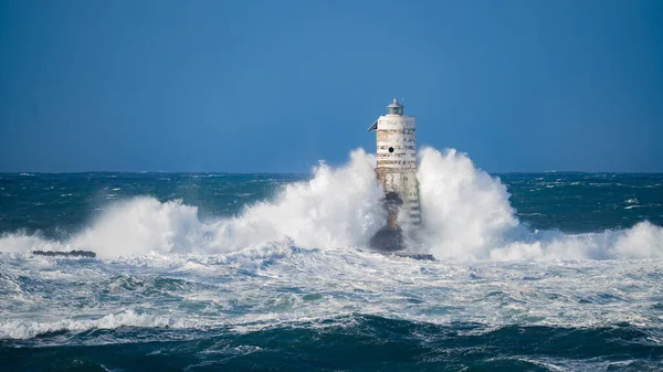 Güçlü fırtına dalgaları, ıssız bir deniz fenerine çarpıyor. Açık deniz koşullarında duruyor..