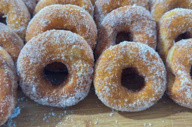 Tahtada şekerle kaplanmış taze kızarmış çörekleri kapat.