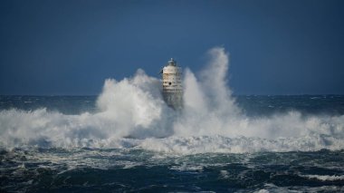 Dramatik okyanus fırtınası ve dayanıklı kıyı feneri, Calasetta Mangiabarche
