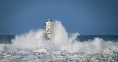 Dramatik okyanus fırtınası ve dayanıklı kıyı feneri, Calasetta Mangiabarche