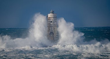 Dramatik okyanus fırtınası ve dayanıklı kıyı feneri, Calasetta Mangiabarche