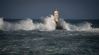 Dramatik okyanus fırtınası ve dayanıklı kıyı feneri, Calasetta Mangiabarche