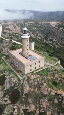 Akdeniz kayalıklarına bakan tarihi deniz feneri, Carloforte Capo Sandalo