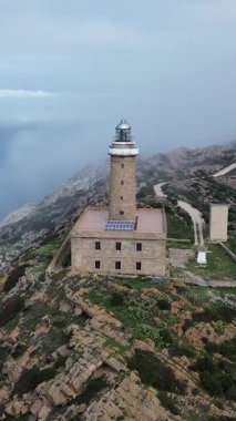 Akdeniz kayalıklarına bakan tarihi deniz feneri, Carloforte Capo Sandalo