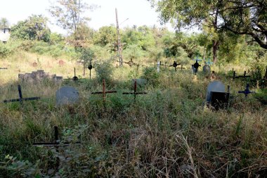 Yeşil çimlerin üzerinde haç ve mezar taşı olan Kızılderili mezarlığı manzarası