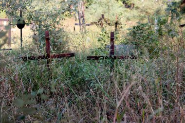 Yeşil çimlerin üzerinde haç ve mezar taşı olan Kızılderili mezarlığı manzarası