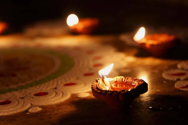 View of clay diyas (Indian clay oil lamp) near rangoli during festive of Diwali