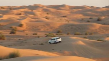4x4 'lük araba sahnesi çöl kumulundan hareket ediyor.