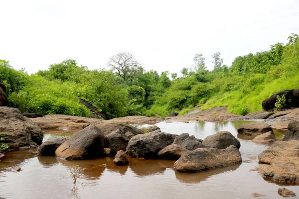 瀑布上方的小运河是干枯的 石头铺满绿草和树木背景 — 图库照片