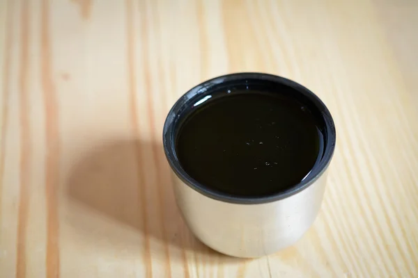 Маленькая чашка кофе на деревянном столе — стоковое фото