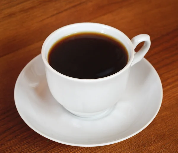 Una taza de café sobre una mesa de madera — Foto de Stock