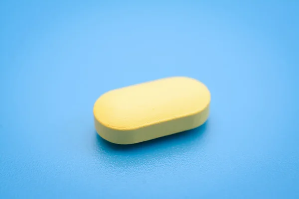 Tabletták, kék háttérrel — Stock Fotó