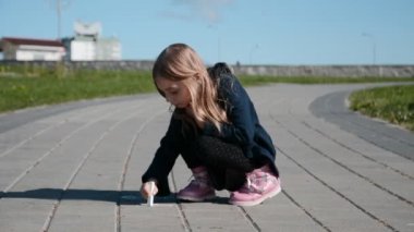 Küçük kız tebeşirle çiziyor patikayı