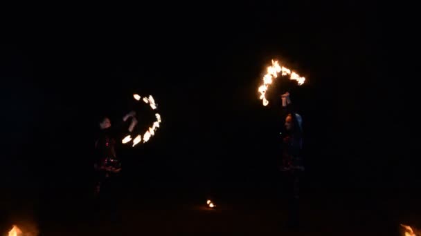 Zwei Mädchen treten bei abendlicher Feuershow mit brennenden Fackeln auf — Stockvideo