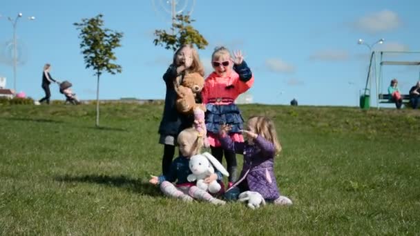 Quatro engraçadas meninas irmãs jogando no parque da cidade — Vídeo de Stock