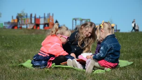 Quatre petites cousines amicales jouent dans le parc sur l'herbe verte — Video