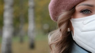 Bir kadının yüzünün yarısı koruyucu maske takıyor.