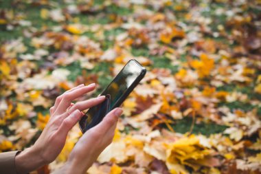 Kadın Eller kapatıyor. Cep telefonunu açık havada kullanın.