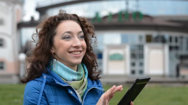 Krásná dívka student usměvavý a psaní zprávu na její tablet — Stock video