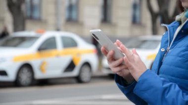 Kadın eli, taksi çağırmak için akıllı telefon uygulaması kullanır.