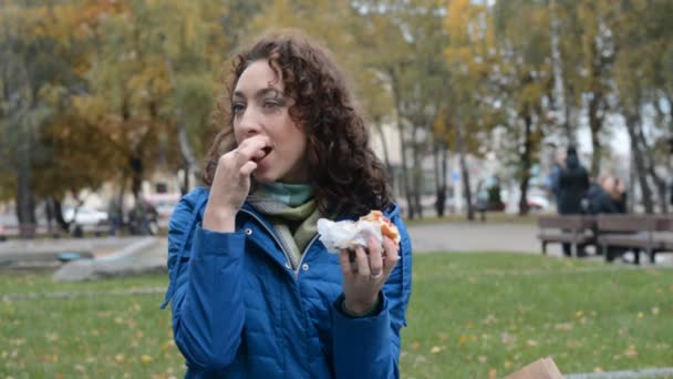 Menina Hipster jovem caucasiano está comendo um hambúrguer Veggie suculento ou hambúrguer — Vídeo de Stock